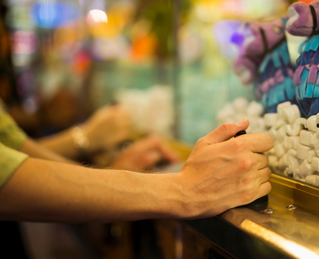 Man spelen met klauw machine op kermis