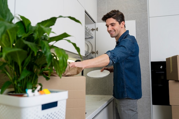 Gratis foto man spullen uitpakken na verhuizing naar een nieuw huis