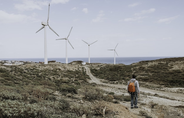 Gratis foto man staande in de buurt van de windturbines