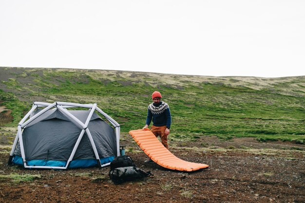 Man staat naast moderne tent in IJsland