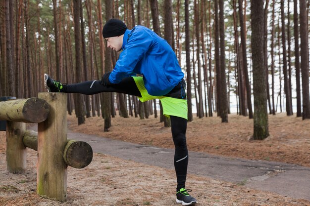 Man stretching been in het bos