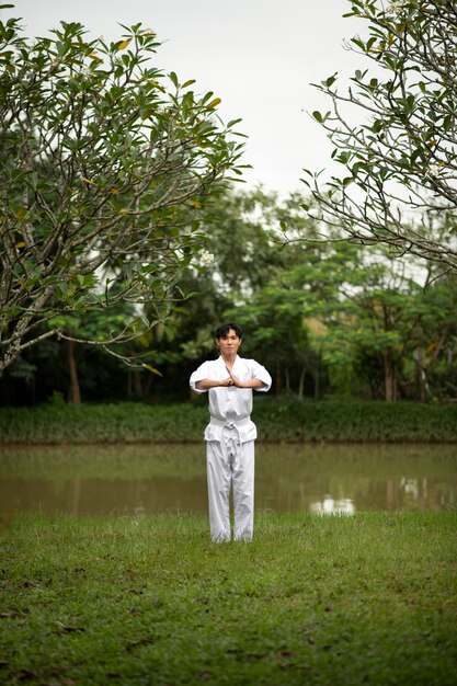 Gratis foto man training in taekwondo buiten in de natuur