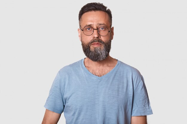 man van middelbare leeftijd het dragen van een bril en caual grijze t-shirt, die zich voordeed op wit met kopie ruimte, man met baard. Mensen concept.