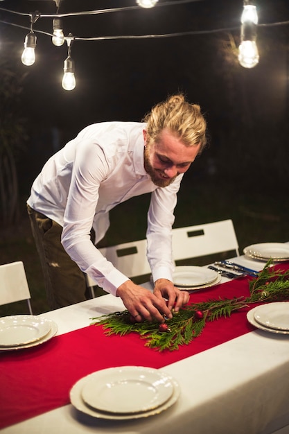 Man versieren tafel voor kerstfeest