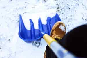 Gratis foto man werknemer in uniform, sneeuw scheppen. close-up afbeelding