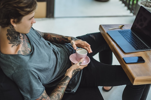 man werkt in een café. concept van freelancen, koffie en laptop