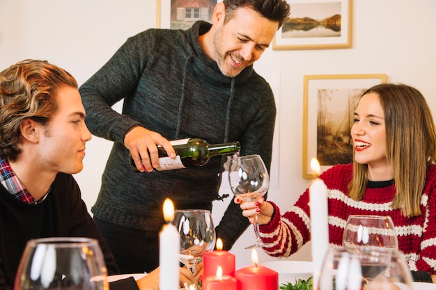 Man wijnglas vullen bij kerstdiner