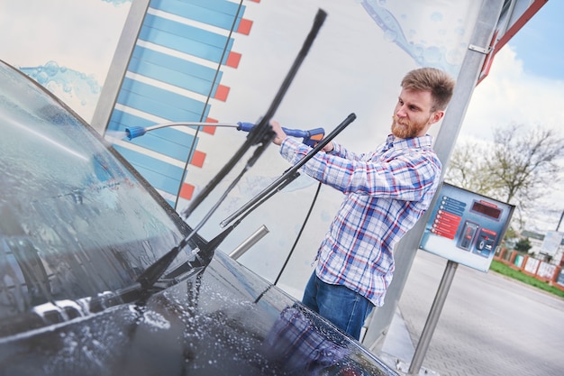 Man zijn auto schoonmaken in een zelfbediening