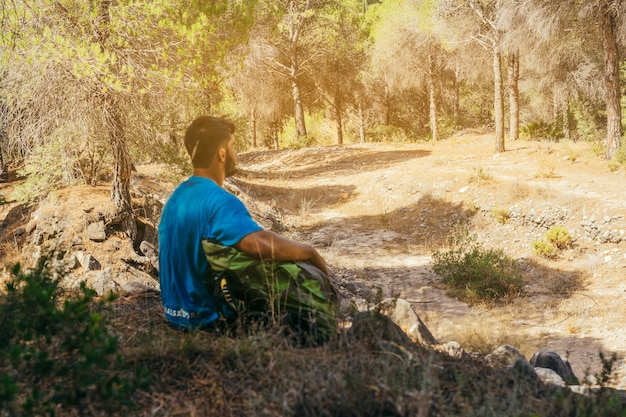 Gratis foto man zit in het bos