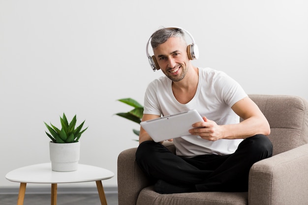 Man zittend op een stoel en een digitale tablet te houden