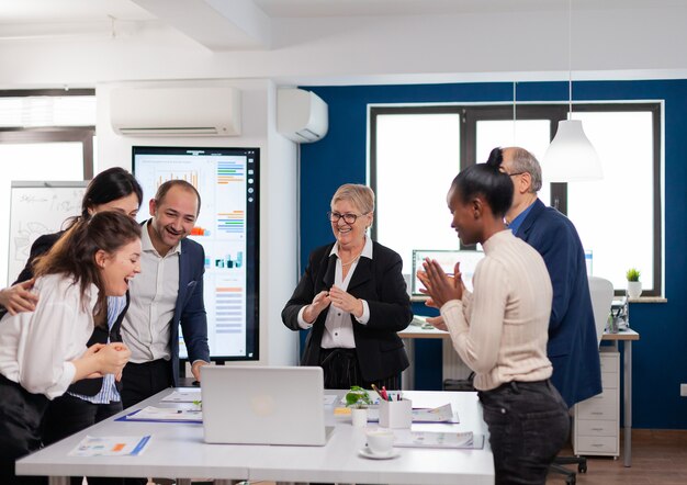 Managementteam applaudisseert dolblij in vergaderruimte na goede training after