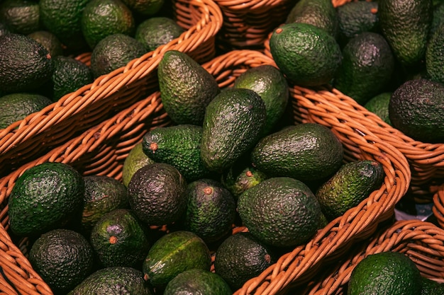 Gratis foto manden met avocado in een supermarkt close-up