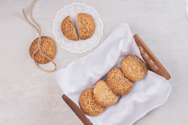 Mandje van koekjes met sesamzaadjes op witte ondergrond.