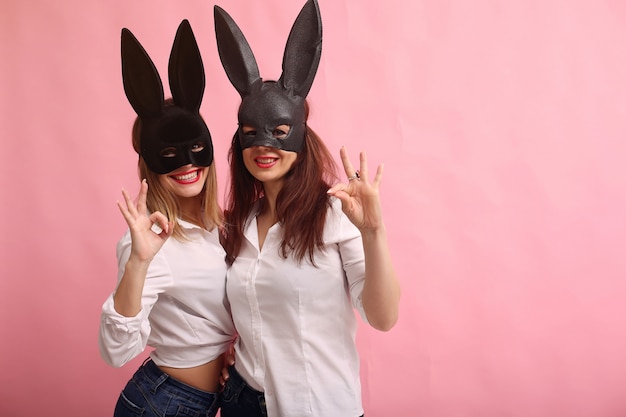 Manier jonge vrouwen die met zwart konijnmasker stellen