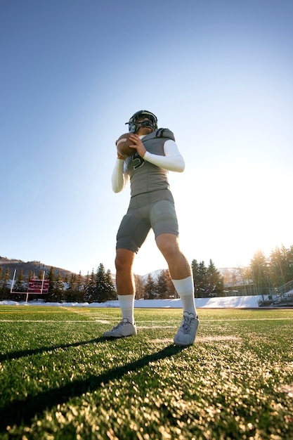 Mannelijke american football-speler in uniforme training op het veld