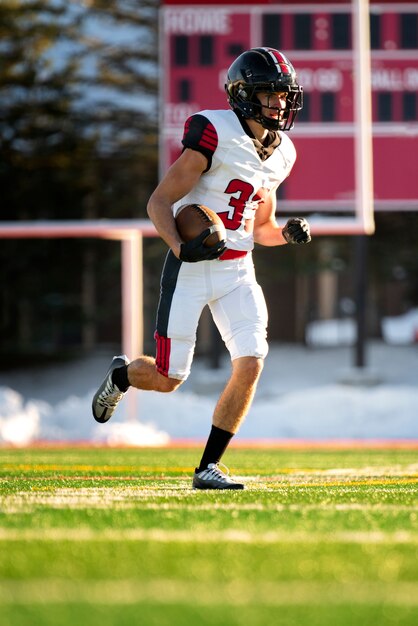 Mannelijke american football-speler in uniforme training op het veld