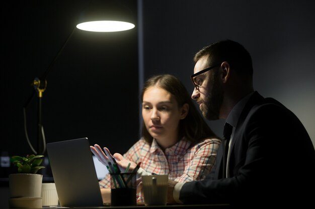 Mannelijke arbeider die marketing plannen verklaart aan vrouwelijke medewerker