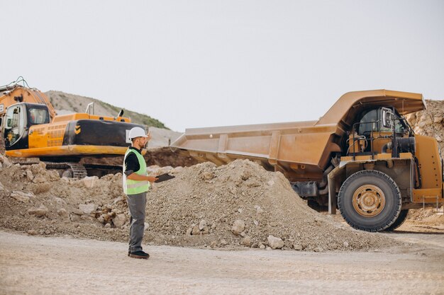 Mannelijke arbeider met bulldozer in zandgroeve