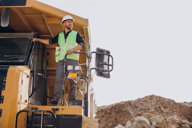 Mannelijke arbeider met bulldozer in zandgroeve