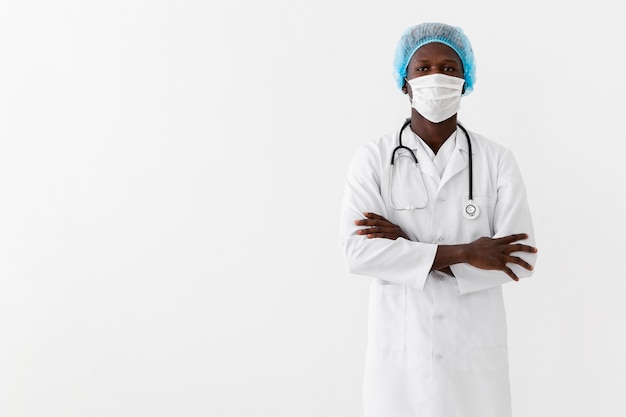 Gratis foto mannelijke arts die wit kleed en masker draagt