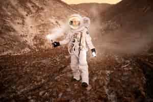 Gratis foto mannelijke astronaut die zijn locatie aangeeft tijdens een ruimtemissie op een onbekende planeet