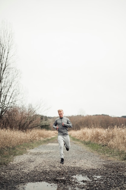 Gratis foto mannelijke atleet die op landweg loopt