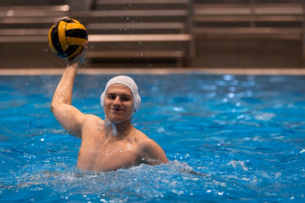 Gratis foto mannelijke atleet die waterpolo speelt in binnenzwembad