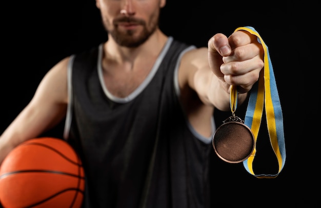 Mannelijke atleet met basketbal met gouden medaille