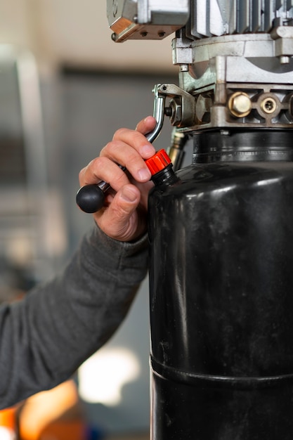 Gratis foto mannelijke automonteur die werkt in de autoreparatiewerkplaats