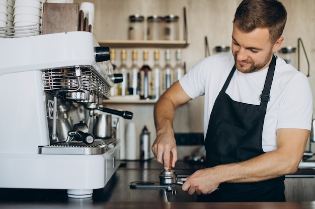 Mannelijke barista die koffie bereidt in een coffeeshop