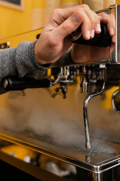 Mannelijke barista holt naar professionele koffiemachine