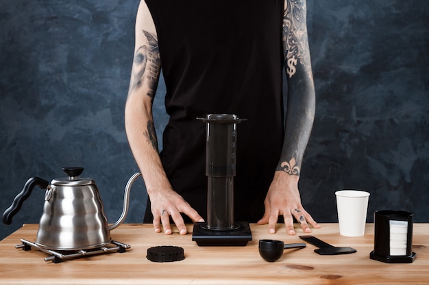 Mannelijke barista koffie brouwen. alternatieve methode aeropress.