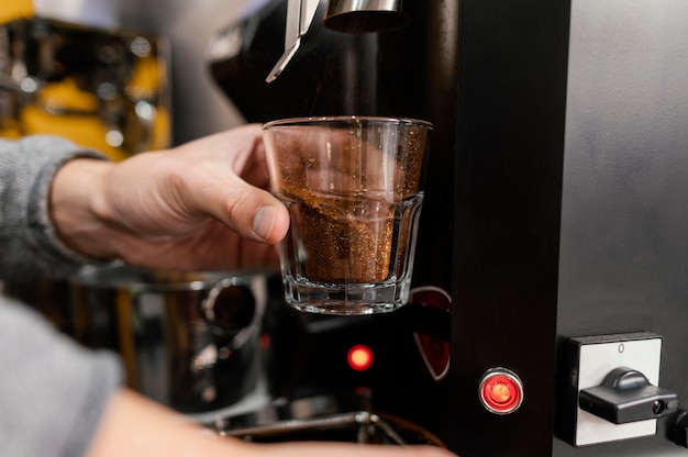 Mannelijke barista koffie malen met machine