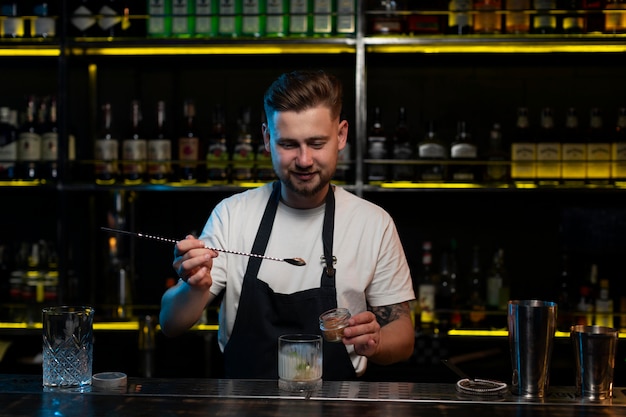 Mannelijke barman die een heerlijke cocktail maakt