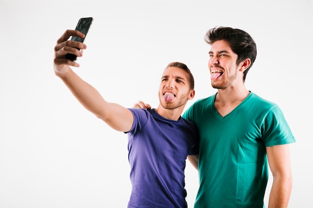 Mannelijke beste vrienden nemen selfie en grimassen