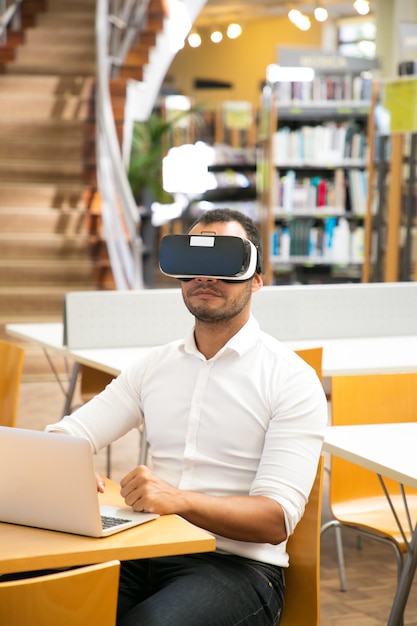 Mannelijke bibliotheekgebruiker die VR-hoofdtelefoon draagt