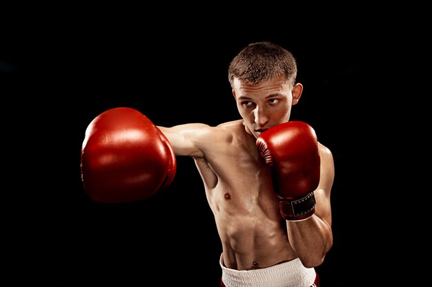 Mannelijke bokser boksen met dramatische edgy verlichting op zwart