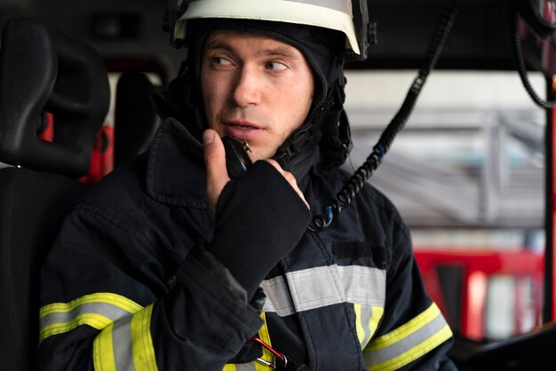 Mannelijke brandweerman in brandweerwagen met radiostation