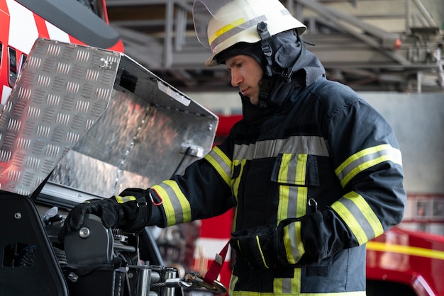 Mannelijke brandweerman op station uitgerust met pak en veiligheidshelm