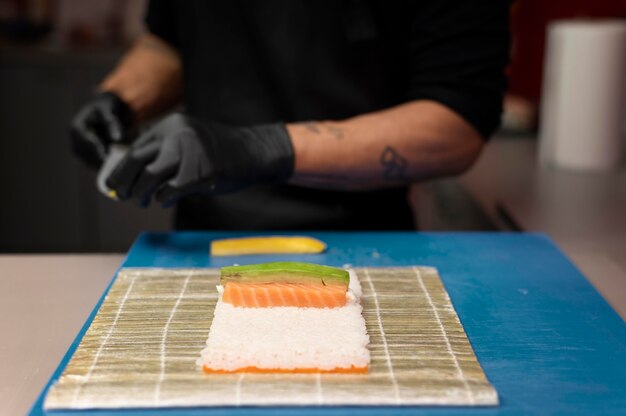 Mannelijke chef-kok bereidt een sushi-bestelling voor een afhaalmaaltijd