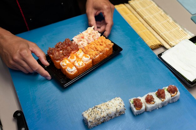 Mannelijke chef-kok bereidt een sushi-bestelling voor een afhaalmaaltijd