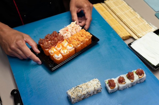 Mannelijke chef-kok bereidt een sushi-bestelling voor een afhaalmaaltijd