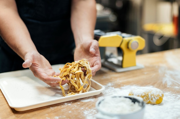 Mannelijke chef-kok die verse deegwaren houdt