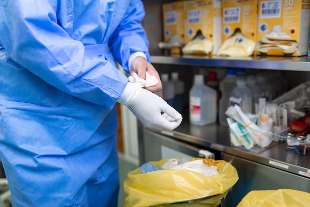 Mannelijke chirurg die chirurgische handschoenen verwijdert in de operatiekamer in het ziekenhuis