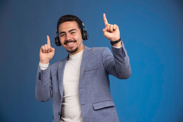 Mannelijke dj in grijs pak hoofdtelefoon dragen en maakt feest.