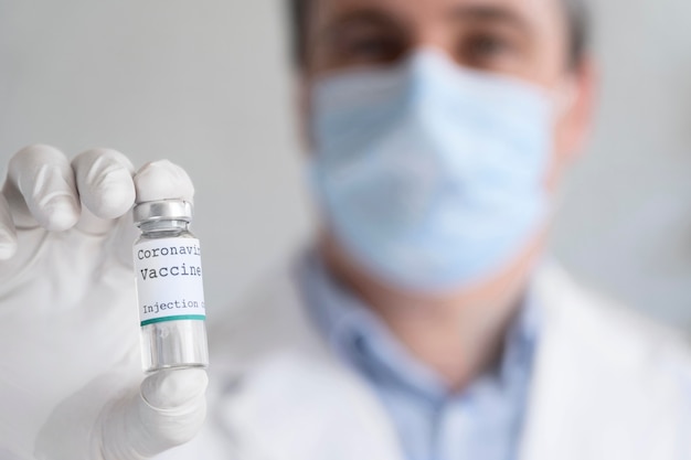 Mannelijke dokter die een injectieflacon met vaccin vasthoudt