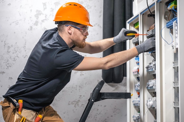 Gratis foto mannelijke elektricien die in een schakelbord met lontjes werkt