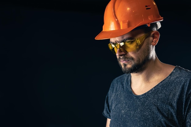 Gratis foto mannelijke elektricien in een beschermende helm met bril op een zwarte achtergrond