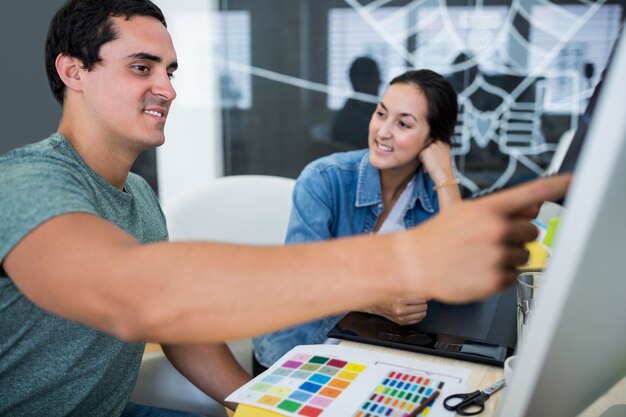 Mannelijke en vrouwelijke grafisch ontwerpers interactie via computer