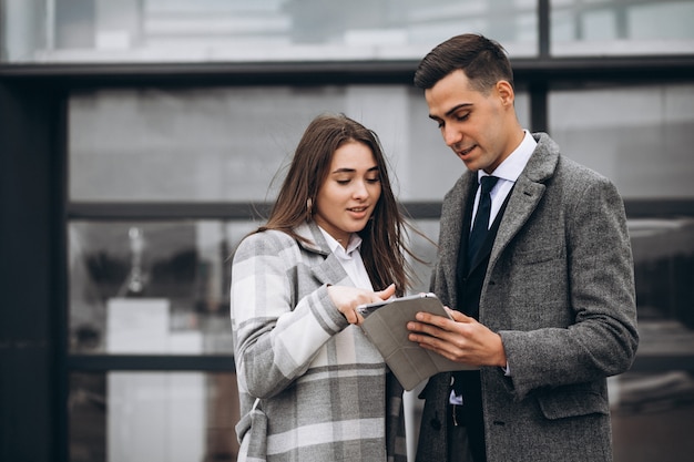 Mannelijke en vrouwelijke zakenmensen werken op tablet in office